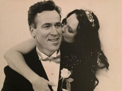 Suanne Braun is kissing Christopher Garner on his cheek.